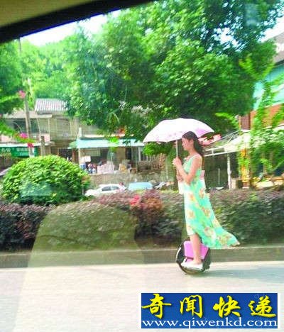 长沙某女子撑伞踩独轮车 从马路"飘过"似幽灵